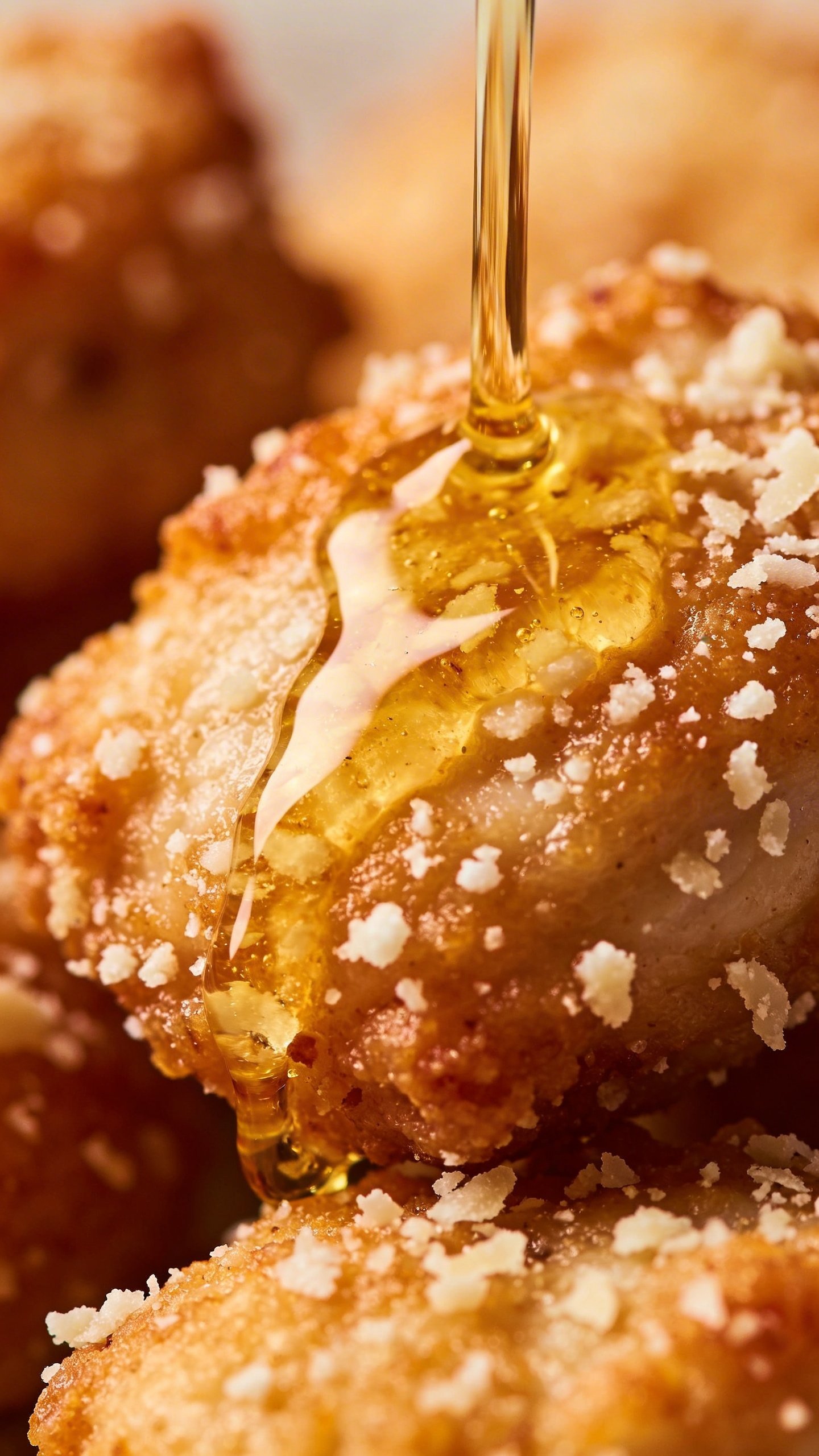 Crispy Perfection: Air Fryer Chicken Bites Tonight 4 Closeup of parmesan-flecked coating on chicken bite with drizzle of oil