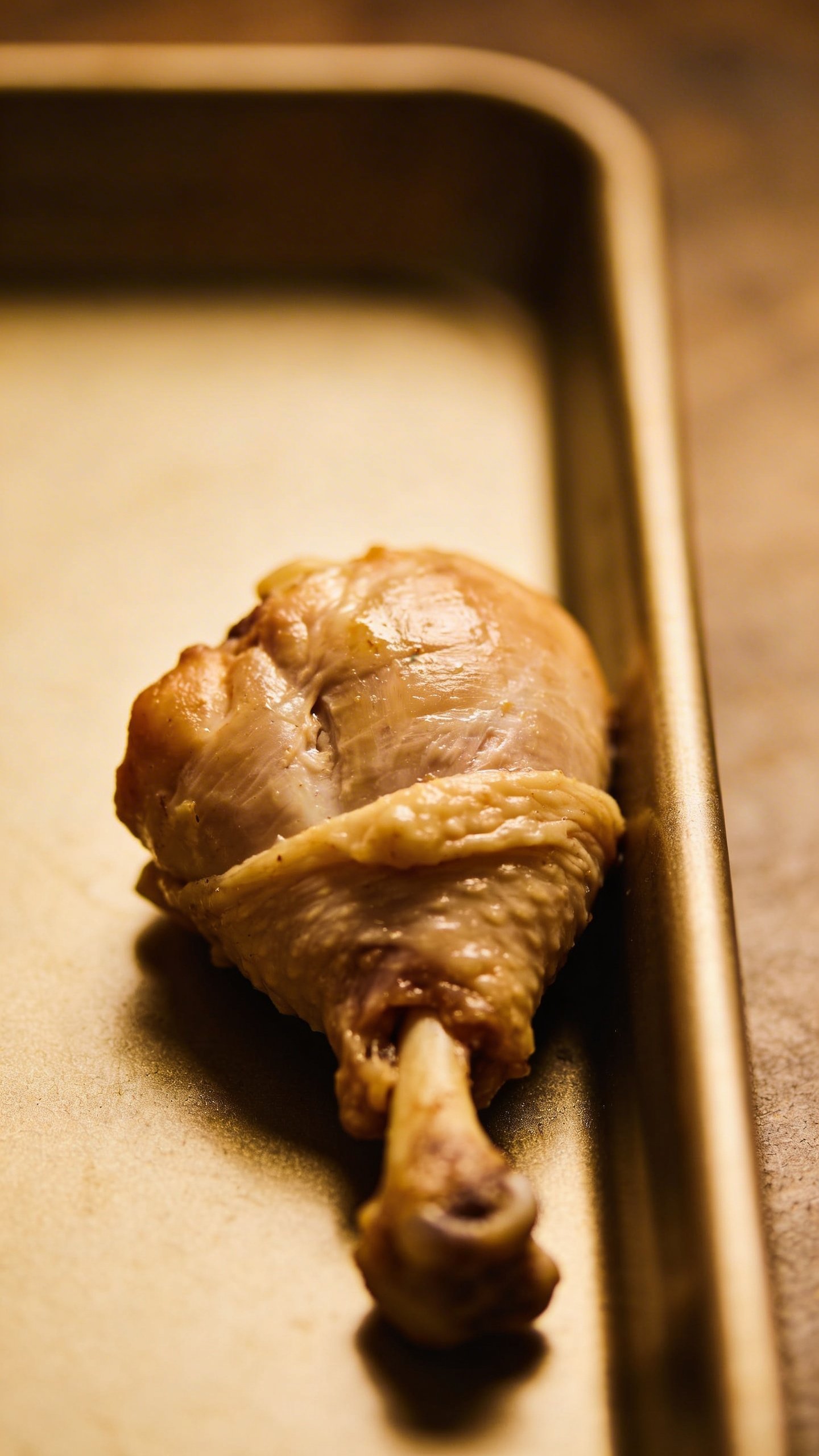 Irresistible Oven Baked Chicken Thighs Tonight 5 closeup of bone-in skin-on chicken thigh resting on baking sheet margin